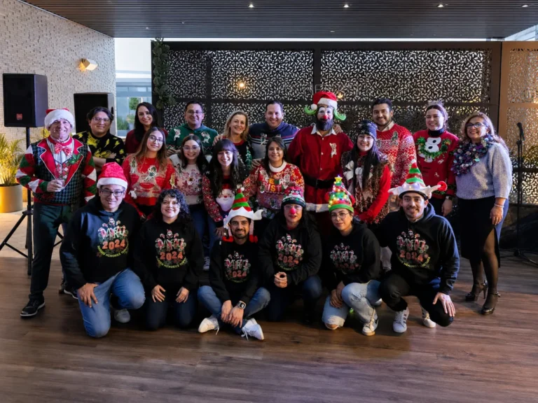 Foto del equipo de trabajo de una empresa en su intercambio de sueteres navideños